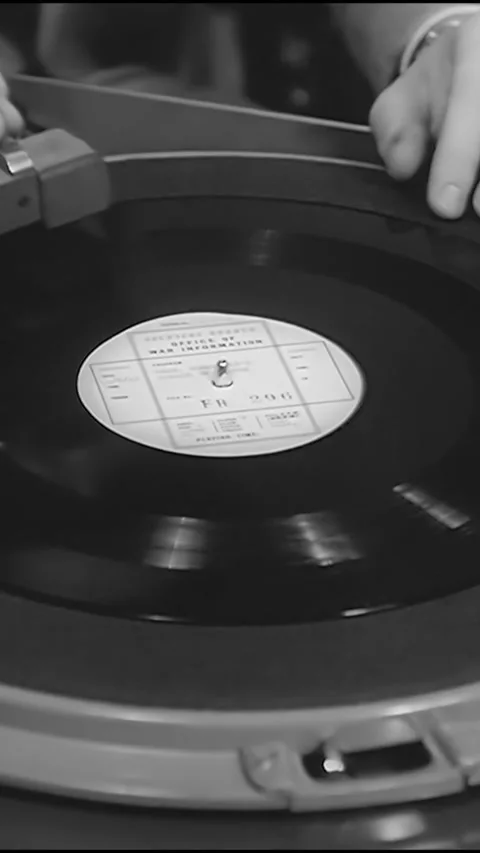 USA - 1942 - A man puts a record of a translated FDR speech onto a phonograph Vídeos de archivo 342279062