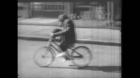 USA - 1950s - A chimp dangerously rides a bicycle. Children work in a school. Stock Footage 327739577