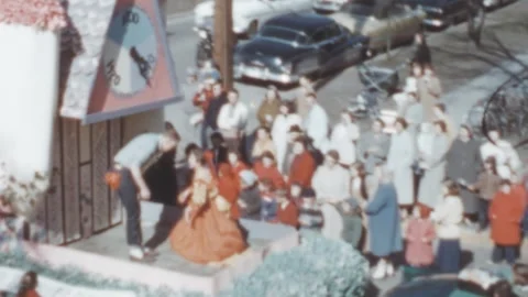 USA - 1950s: crowd claps at a cuckoo clock float during a parade Video stock 258215517