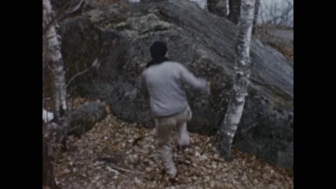 USA - 1950s: A guy in the forest jumps on a rock Video stock 158798385