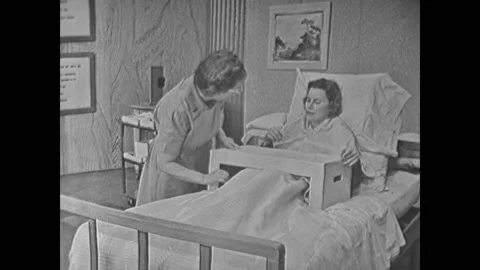 USA - 1950s - A nurse sets up a bed table for a bedridden patient and talks Stock Footage 313139570