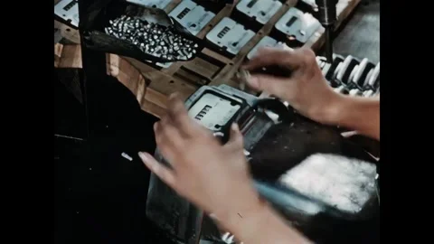 USA - 1950s - Overhead power tools are used to drill screws into mass produced Stock Footage 340660111