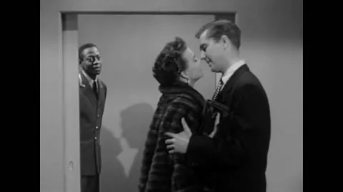 USA - 1952 - In this comedy, a man and woman exit an elevator and kiss. The Stock-Footage 327742979