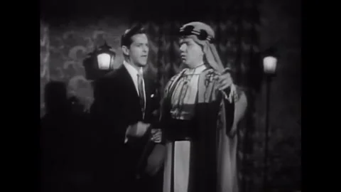 USA - 1953 - In this comedy, a man puts down a package and men dressed in Arab Stock Footage 341991823
