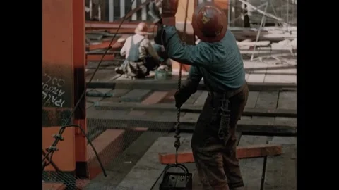 USA - 1957 - Construction workers put hand tools in a small basket which gets 動画素材 340667029