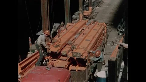 USA - 1957 - Construction workers tie ropes around a bundle of steel beams and Stock Footage 340667042