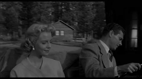 USA - 1958 - In this sci-fi horror, a man and woman ride in an open top car. A Stock-Footage 323081791