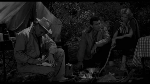 USA - 1958 - In this sci-fi horror, three people sit around a fire in a Video stock 323083445