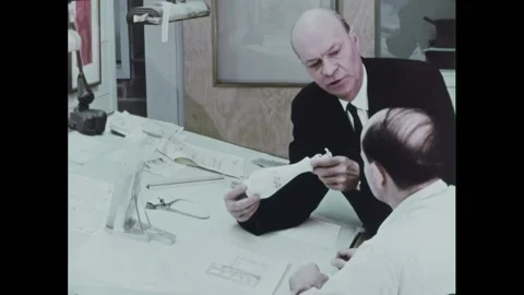 USA - 1960 - Men meet at a drafting table reviewing the design of a bottle. All Stock Footage 328189197