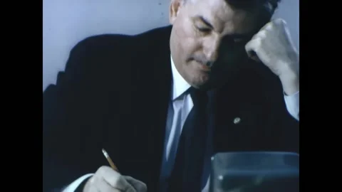 USA - 1963 - Men listen to an intercom in a boardroom, taking notes. An airplane Stock Footage 327742132