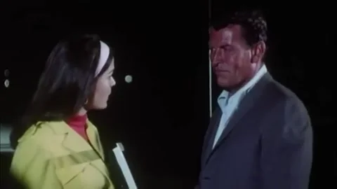 USA - 1966 - In this sci-fi spy thriller, a man talks with a woman at a police 스톡 동영상 325211674