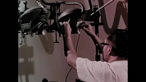 USA - 1969 - A man puts two slides in a projector, looking at different colored Stock Footage 327742244