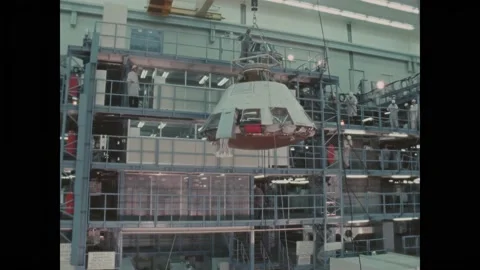 USA - 1969 - NASA technicians lower a command module onto a dolly using a crane. Stockbeeldmateriaal 313047653