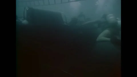 USA - 1970 - Two divers work on the underwater Amphibious Transport Submarine Stock Footage 296689878