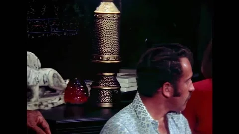 USA - 1972 - In this horror sci-fi, men and women lounge at a 70s party. A man 스톡 동영상 325211406