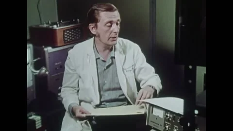 USA - 1972 - A man examines items in two sealed envelopes, comparing them to the Stock Footage 327741793