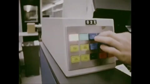 USA - 1972 - A man uses a computer to process paper data. Stock Footage 259380280