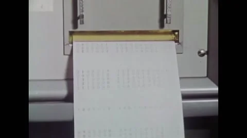 USA - 1972 - Numbers are printed out of a machine. A blonde man with a beard has Stock Footage 327736146