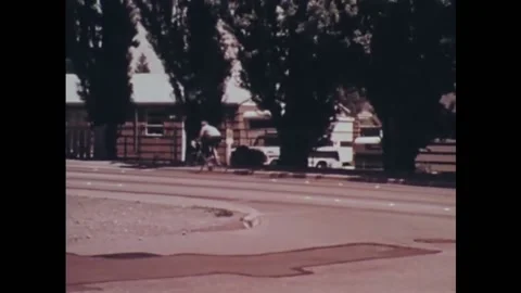 USA - 1973 - A cop pulls over a bicyclist for running a stop sign and issues him Stock Footage 259379934