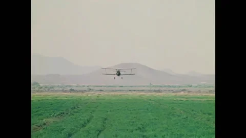 USA - 1974 - A plane crop dusts a field. A horse is loaded onto a trailer. Stock Footage 328186053