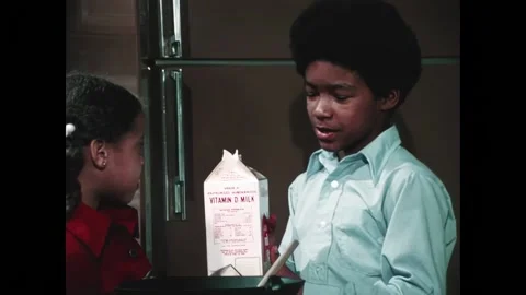 USA - 1976 - A boy pulls a carton of milk from a fridge and pours it in a square Stock Footage 328187883