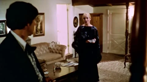 USA - 1977 - In this sci-fi horror, a dressed up man and woman speak in a home. 库存影片 327743302