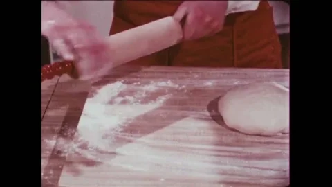USA - 1981 - A baker uses a rolling pin and his hands to shape bread dough. 動画素材 261572036
