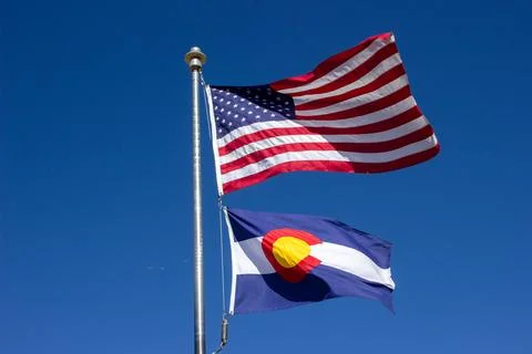 USA and Colorado flags in the wind and clear sky Stock Photos
