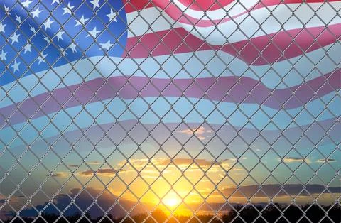 USA flag and migration border fence against the sunset Illustrazione stock