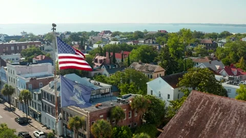 USA flag in Charleston, aerial pullback reveals St. Michael's church in Stock Footage 157794099
