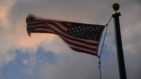 USA Flag floating on the wind with a cloudy orange and blue sky Stock-Footage 135346420