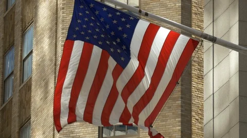 USA flag flying outside of a building on Wall Street, Manhattan Island, New York Stock Footage 88200225