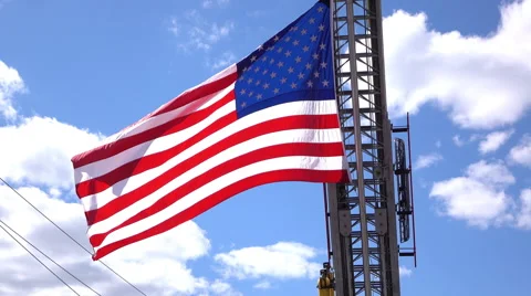 USA Flag in front of blue sky hanging from firetruck ladder 4k Stock-Footage 58479570