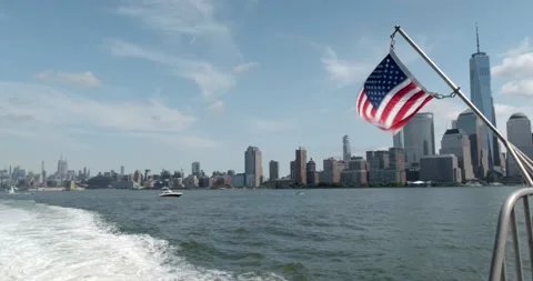 USA Flag Waves From A Ferry With The New York City downtown cityscape - 4K NYC Stock Footage 207605425