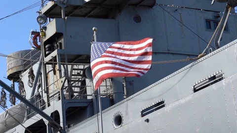 USA flag waving at wind in front of a military ship, slow motion Stock Footage 122150756