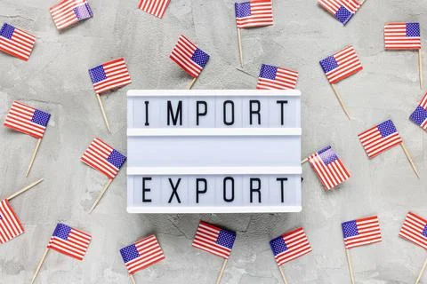USA flags and text IMPORT EXPORT on gray Stock Photos