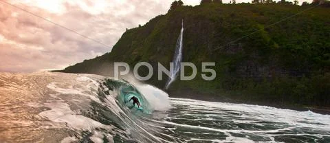 USA, Hawaii Islands, Huge wave with man inside barrel at sunset Stock Photos