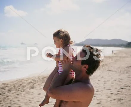 USA, Hawaii Islands, Man with his daughter (4-5) relaxing on beach Stock Photos