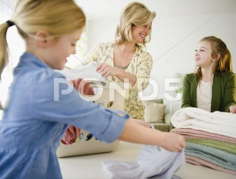 USA, Jersey City, New Jersey, mother and daughters (8-11) doing laundry Stock Photos