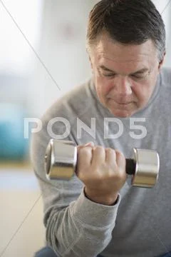 USA, New Jersey, Jersey City, Fitness instructor assisting man using hand weight Stock Photos