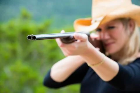 USA, Texas, Mid adult woman aiming rifle Фото