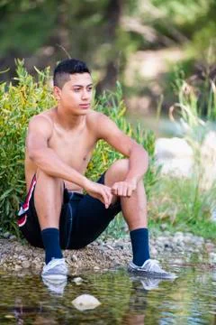 USA, Texas, Teenage boy sitting at Frio River Stock Photos