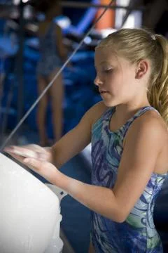 USA, Utah, Orem, girl (10-11) in gym applying talcum powder to hands Stock Photos