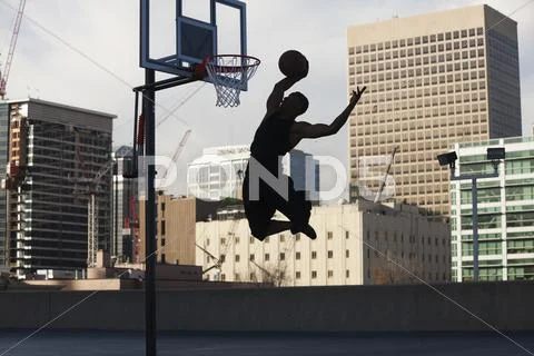 USA, Utah, Salt Lake City, Silhouette of young man playing basketball Stock Photos