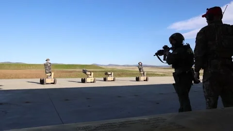 USAF Security Forces firing machine gun at moving AI-powered autonomous robots Stock Footage 300439989