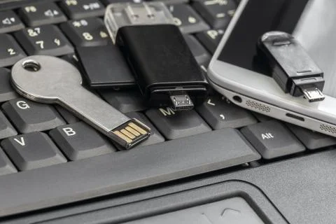 USB  and micro USB keys with  smartphone on the laptop keyboard Stock Photos