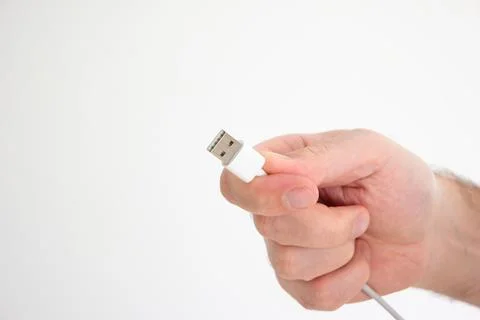 USB cable ad connector held in hand by Caucasian male hand isolated on white  스톡 사진
