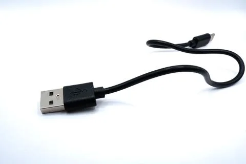 USB cable connected to a flash drive for data transfer and storage. Compact Stock Photos