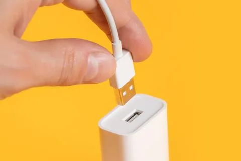 Usb cable in hand with usb connector on yellow background Stock-Fotos