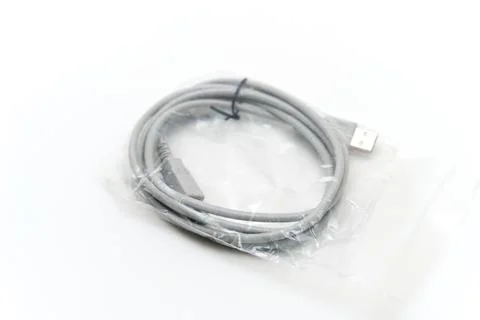 USB cable in plastic packaging placed on a white surface Stock Photos